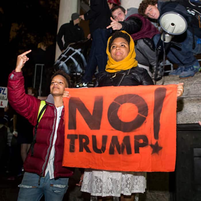A family holding anti-Trump slogan outside Trump tower