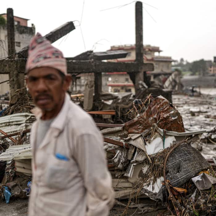 A local resident stands near destroyed structures and piles of debris along the Trishuli River, at Devighat, in Nuwakot district, Nepal