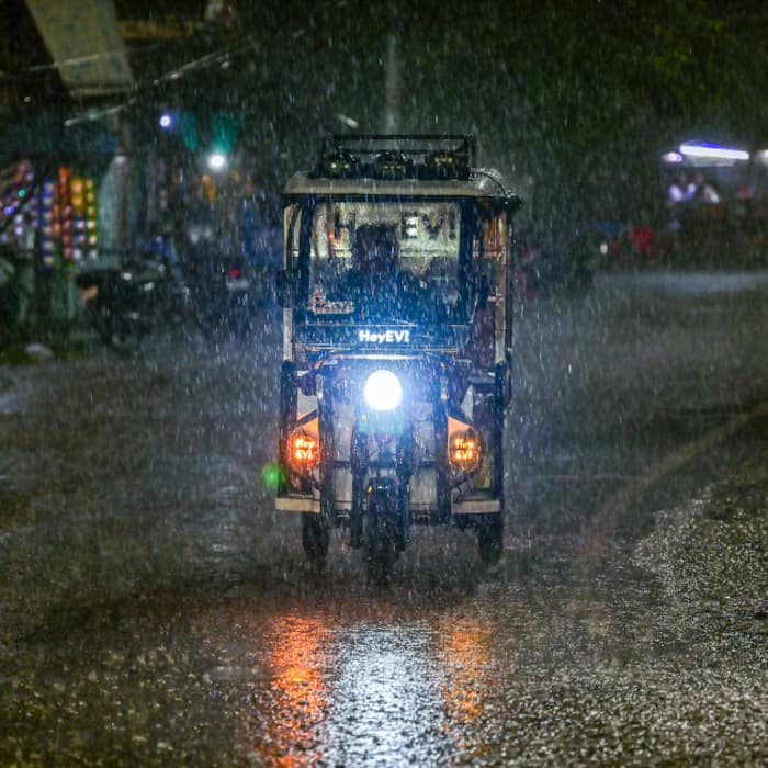 A man rides an e-rickshaw amid rainfall, in Prayagraj, Uttar Pradesh