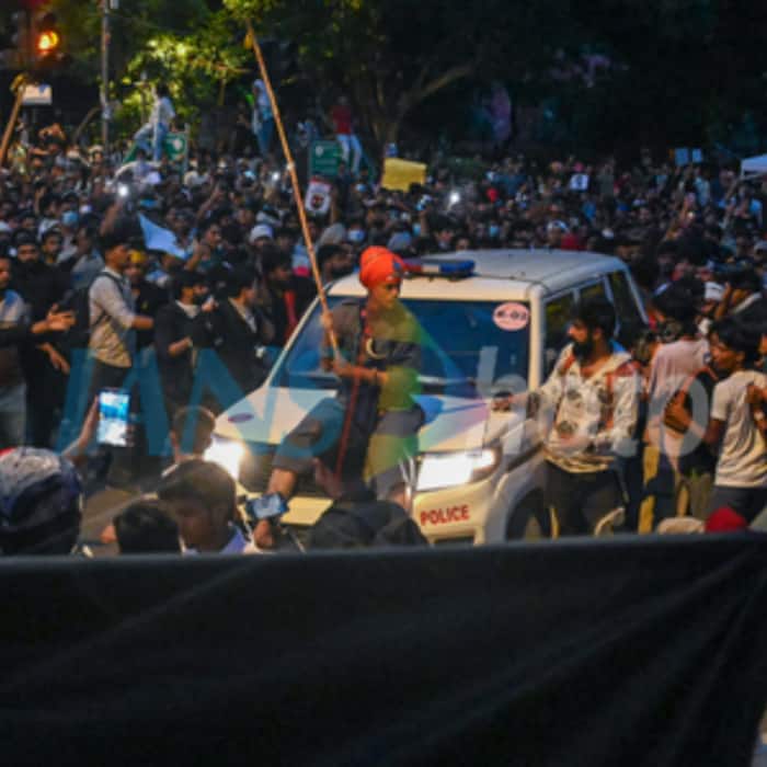 A supporter of Cockroach Janta Party (CJP) climbs a vehicle during the ongoing protest demanding the resignation of Union Education Minister Dharmendra Pradhan