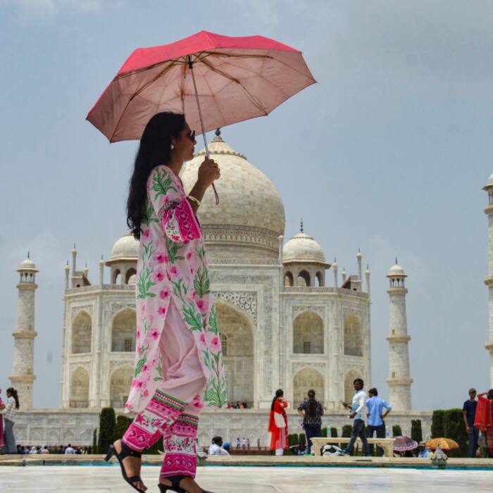 A visitor covers herself amid scorching heat, at Taj Mahal, in Agra, Uttar Pradesh