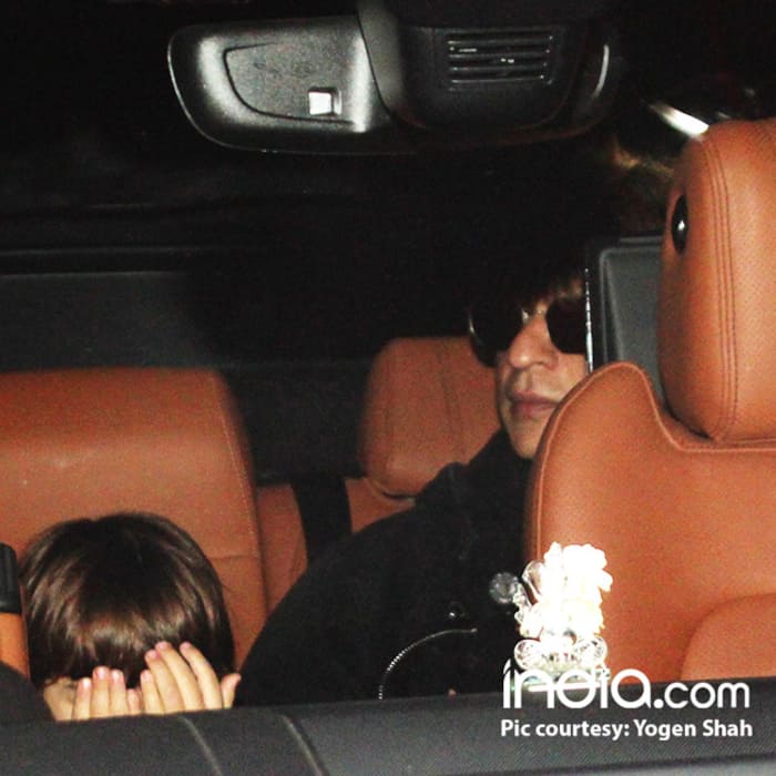 Abram Khan covers his face from photos