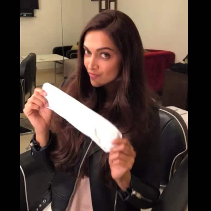 Deepika Padukone with a pad in her hand