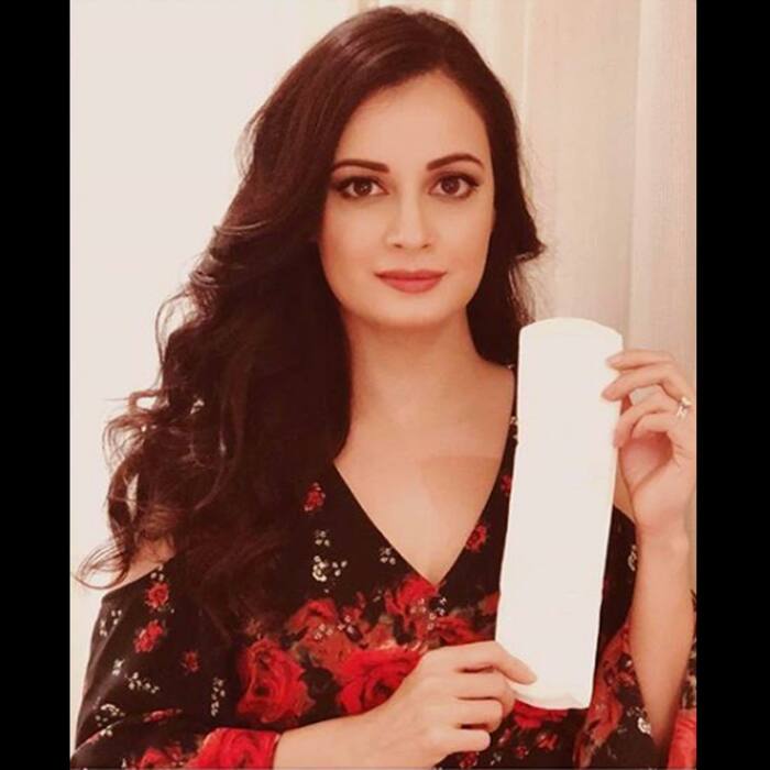 Dia Mirza posing with pad in her hand
