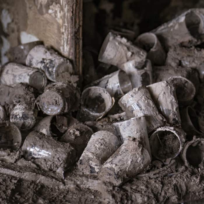 Mud-covered drinking glasses lie scattered inside a damaged shop along the Trishuli River, at Devighat, in Nuwakot district, Nepal