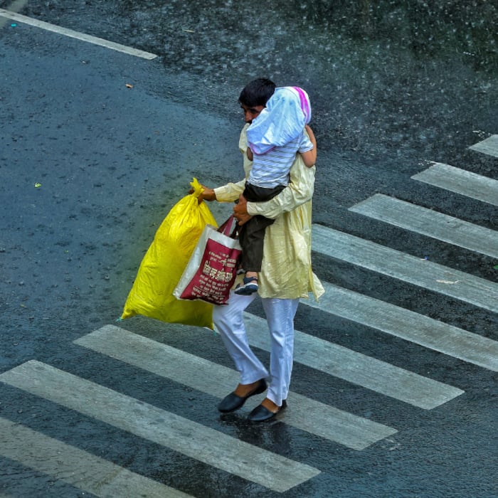 Pedestrians walk amid rain, in Jaipur
