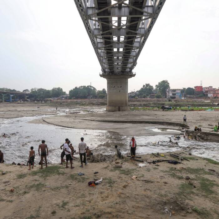 People gather near a waterbody after rainfall, in Prayagraj