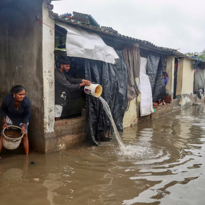People remove rainwater inundating their houses at a waterlogged locality following heavy monsoon rainfall, at Bareja, in Ahmedabad district
