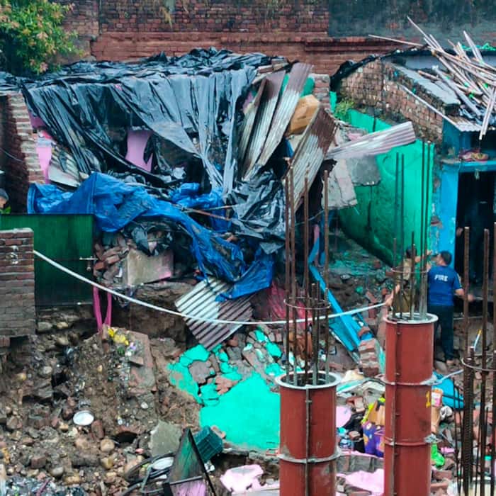 Police and Fire Service personnel rescue residents trapped inside a house damaged by heavy rainfall, in Haridwar