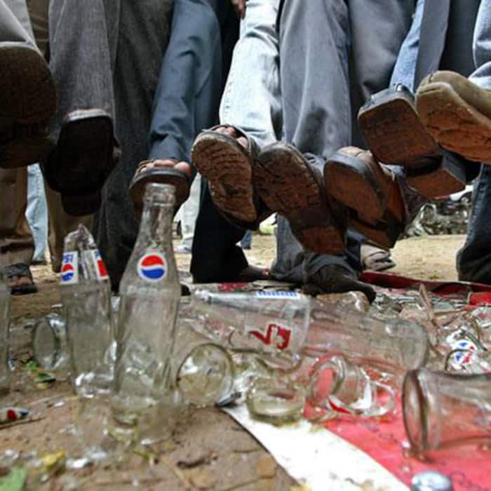 Residents of Tamil Nadu destroying Pepsi and Coca Cola bottles