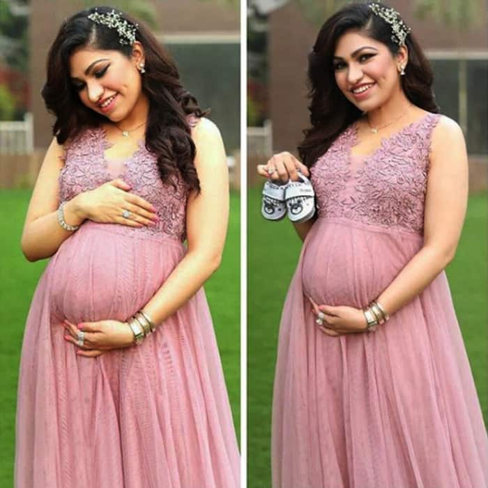 Singer Tulsi Kumar poses with infant shoes in hands