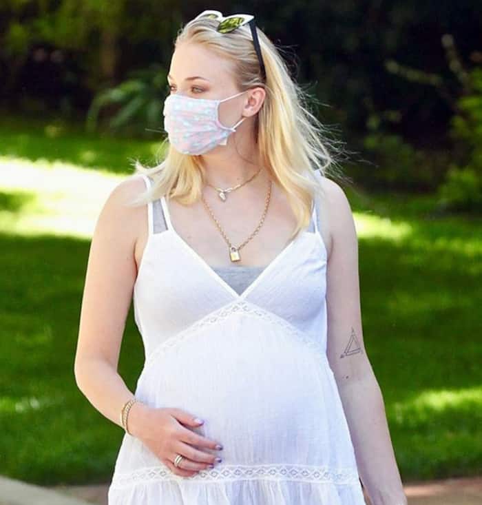 Sophie Turner covers her growing baby bump in a tight dress