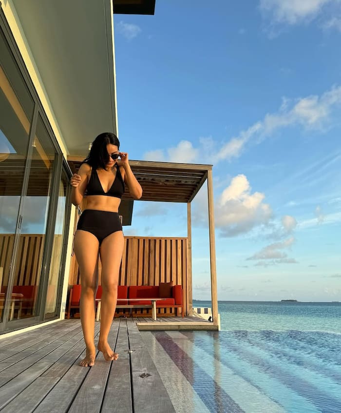 Surbhi Jyoti stands on the edge of a pool to pose for the camera