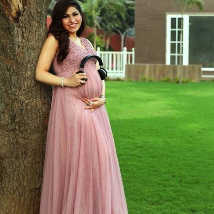 Tulsi Kumar holding headphones over her baby bump