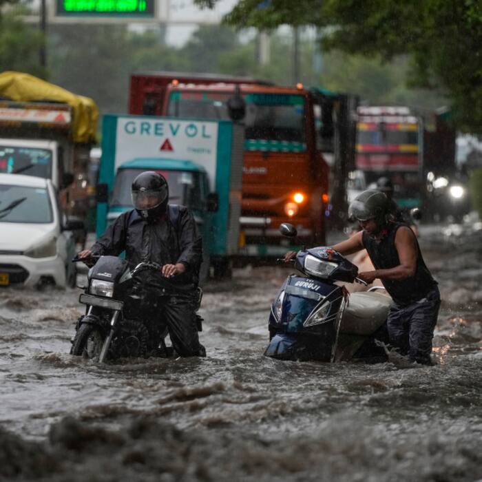 Vehicles move through a waterlogged road amid heavy rain, in the ITO area, New Delhi