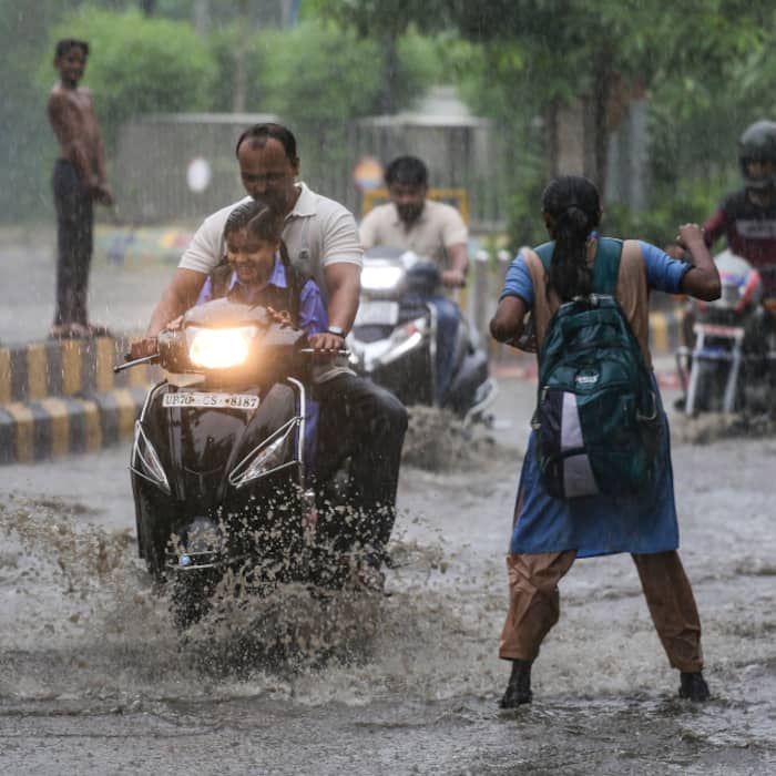 Vehicles ply on a road amid rain, in Prayagraj