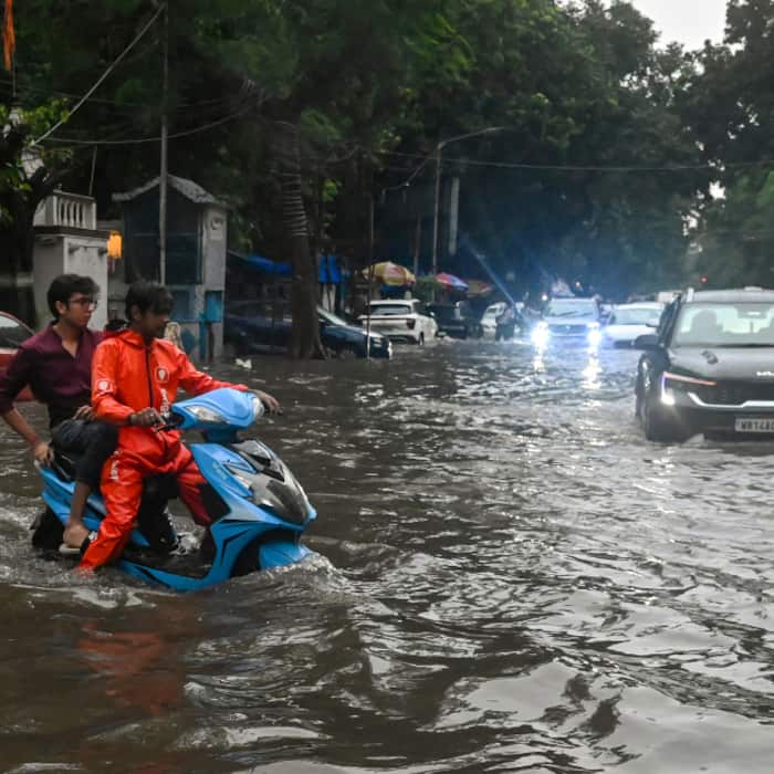 Vehicles wade through a waterlogged road after rainfall, in Kolkata